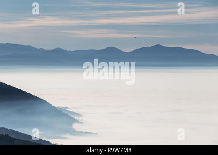 Nebel füllen ein Tal in Umbrien (Italien), die mit den Schichten der Berge und Hügel und verschiedene Schattierungen von Blau Stockfoto