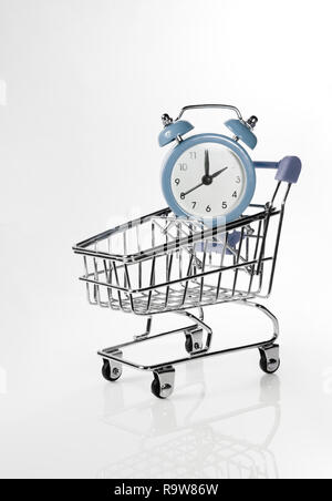 Wecker in einem Einkaufswagen auf einem weißen Hintergrund. Stockfoto