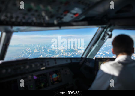 Pilot in einem Verkehrsflugzeug Flug Cockpit während des Fluges mit super Wetter Stockfoto