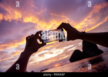 Nahaufnahme der Hände ein Foto vom Handy. Der Provinz Krabi, Railay Beach auf Hintergrund Stockfoto