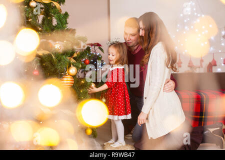 Glückliche Familie mit Tochter Weihnachtsbaum dekorieren Stockfoto