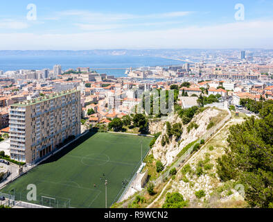 Panoramablick über Marseille, Frankreich, und der alte Hafen von Notre-Dame de la Garde Basilika mit Di Giovanni Fußballplatz im Vordergrund. Stockfoto