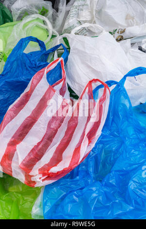 Mehrere Einkaufstaschen aus Kunststoff/Tragetaschen. Für Plastiktütensteuer, Gepäckgebühr, Krieg gegen Kunststoff, Kunststoffverschmutzung UK, Haufen-RM als erkennbare Farben. Stockfoto