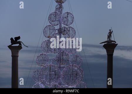 Weihnachtsbaum zwischen der Spalte von Saint Mark (Colonna di San Marco) und der Spalte des hl. Theodoros (Colonna di San Todaro) In Piazzetta di San Marco in Venedig, Italien installiert. Stockfoto