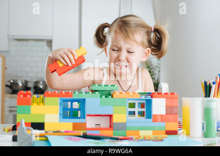 Charmante Vorschüler spielen mit Puppenhaus Konstruktor. Kleine Mädchen spielen mit Spielzeug Würfel Stockfoto