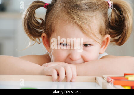 Charmante Vorschüler spielen mit Holz- Konstruktor. Kleine Mädchen spielen mit Anschlussstücken Stockfoto