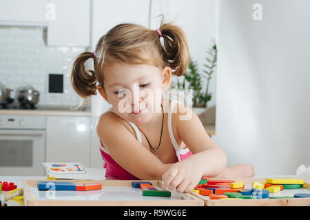 Charmante Vorschüler spielen mit Holz- Konstruktor. Kleine Mädchen spielen mit Anschlussstücken Stockfoto