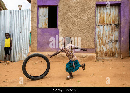 Mädchen spielen Improvisieren mit Fahrrad Reifen in der Turmi Markt, Äthiopien Stockfoto