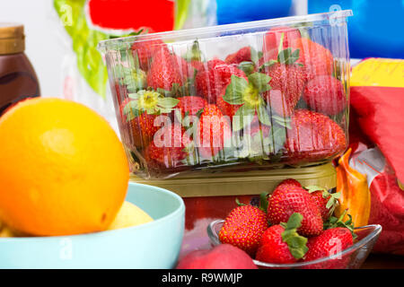 Das Chaos auf dem Küchentisch mit Früchten wie Erdbeeren und Orangen und andere Dinge myny Stockfoto