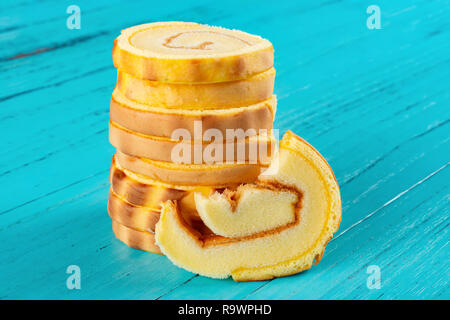 Stapel von Golden süße Brötchen mit ein bisschen auf blauem Holz Hintergrund Stockfoto