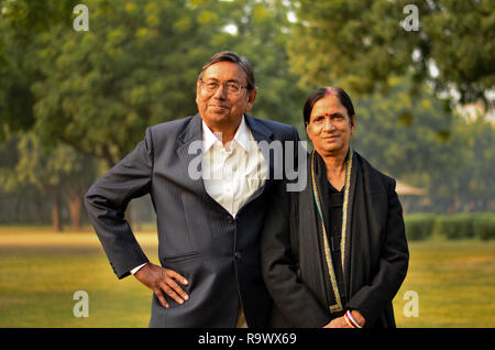 Gerne suchen pensionierte ältere indische Mann und Frau Paar lächelnd und in einem Park im freien Posieren Stockfoto