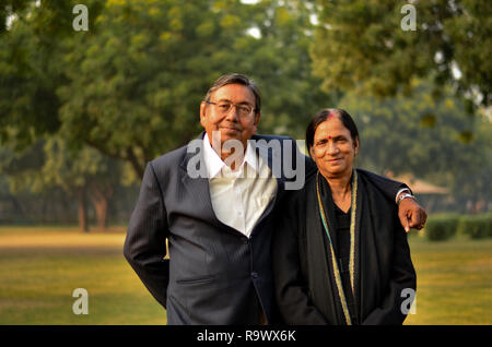 Gerne suchen pensionierte ältere indische Mann und Frau Paar lächelnd und in einem Park im freien Posieren Stockfoto