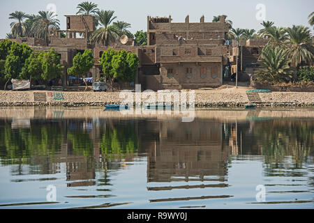 Blick über den großen breiten Fluss Nil in Ägypten Edfu durch ländliche Landschaft Landschaft mit afrikanischen Häuser am Flussufer Stockfoto