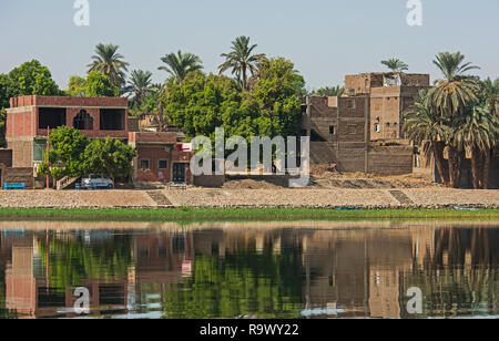 Blick über den großen breiten Fluss Nil in Ägypten Edfu durch ländliche Landschaft Landschaft mit afrikanischen Häuser am Flussufer Stockfoto