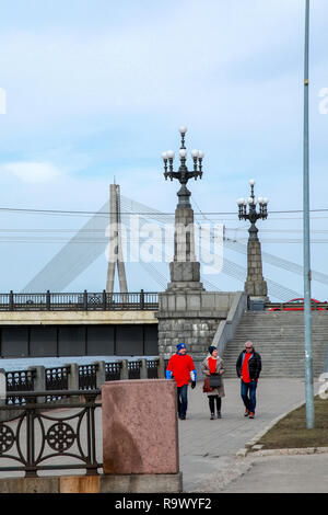 Ansicht des Akmens Brücke aus dem 11. November Böschung. Treppen die steinerne Brücke und Laternen in Riga, Lettland. Hinter dem Akmens Vansu Brücke - Stockfoto