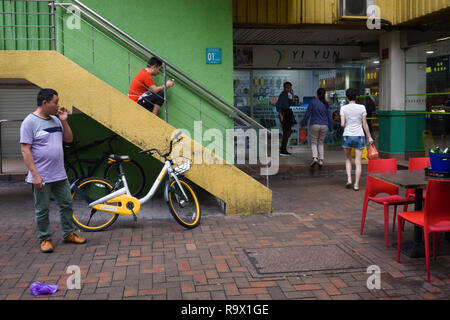 Hinterhof eines HDB Wohnanlage in Chinatown, Singapur, einschließlich ein kleines Restaurant und Männer entspannen Stockfoto