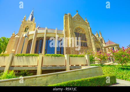 Seitliche Sicht auf die St. Mary's Cathedral mit Glasmalereien in Perth, Western Australia. Der Garten rund um die Kathedrale im neugotischen Stil. Sommer Saison. Blue Sky. Sehenswürdigkeiten in Perth, die Hauptstadt der WA. Stockfoto