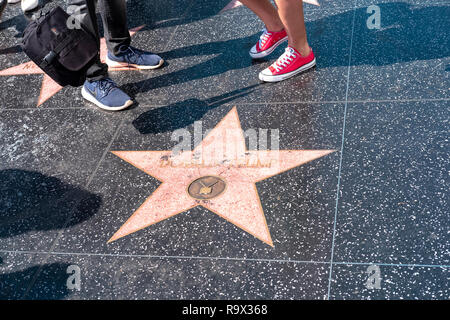 Zwei Paar Füße neben dem Donald Trump Stern auf dem Hollywood Walk of Fame, Hollywood Boulevard, Los Angeles, USA Stockfoto