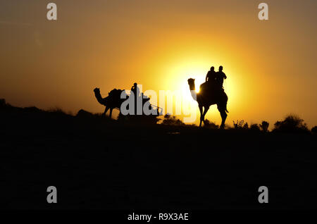 Silhouette einer camel Warenkorb und Kamel Touristen in Sam Sanddünen, Jaisalmer, Rajasthan. Mitten in der Wüste Thar entfernt Stockfoto