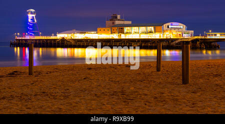 Bournemouth, Dorset, England, 28. Dezember 2018. Der berühmte Pier in 1880 gebaut, voller Attraktionen für Touristen abends beleuchtet Stockfoto