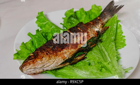 Den gegrillten Wolfsbarsch mit currypaste auf Salatblättern. Menü im Restaurant. Stockfoto