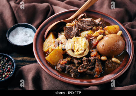 In der Nähe der traditionellen jüdischen Cholent Hamin - Hauptgericht für den Schabbat Mahlzeit, langsam gekochtes Rindfleisch mit Kartoffeln, Bohnen und braune Eier in einer Schüssel auf einem Tropfen Stockfoto