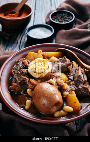 In der Nähe der traditionellen jüdischen Cholent Hamin - Hauptgericht für den Schabbat Mahlzeit, langsam gekochtes Rindfleisch mit Kartoffeln, Bohnen und braune Eier in einer Schüssel auf einem WOODE Stockfoto