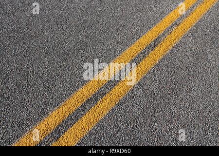 Asphalt Fahrbahn Fahrbahnoberflächen. Grauer Hintergrund mit der gelben Linie. Stockfoto