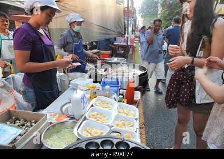 BANGKOK, THAILAND - 21. Dezember 2013: Street Hersteller kocht typisch thailändisches Essen in Thailand. 26,7 Millionen Menschen in Thailand 2013 besucht, einige von ihnen t Stockfoto