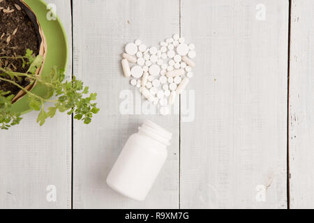 Medizinisches Konzept - Weiß Herz von Pillen und Kapseln auf weißem Schreibtisch aus Holz Stockfoto