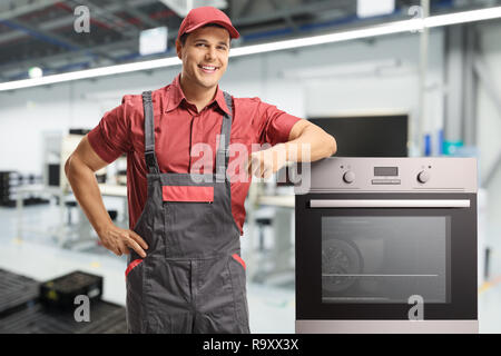 Männliche Arbeiter in einer einheitlichen stand neben einem elektrischen Ofen in einer Fabrik Stockfoto