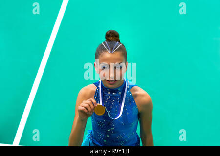 Medaillenträger Gymnastik Teen Girl holding Medaille mit blauem Kleid Stockfoto