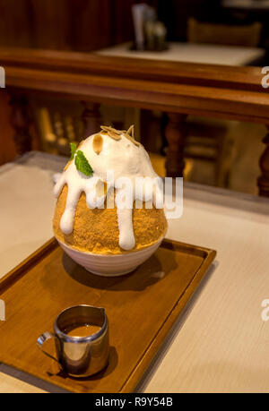 Eine Schokolade, die eisigen Vulkan mit weißem Zucker Belag auf einem Tisch mit einem Restaurant. Stockfoto