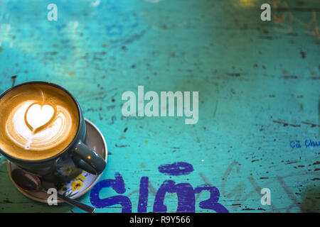 Eine kleine Tasse und Untertasse von Cappuccino auf einem turquose Tabelle. Stockfoto