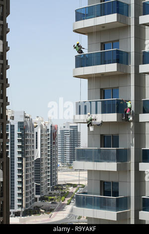 Drei Hochhaus Arbeitnehmer waschen Fenster eines Hochhauses in Dubai Stockfoto