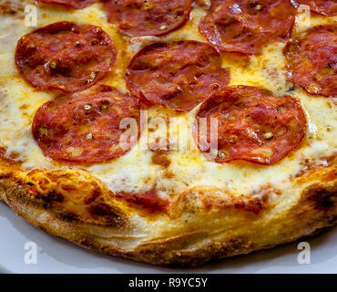 Nahaufnahme von Pepperoni Pizza ungeschnitten, schöne Kruste. Stockfoto