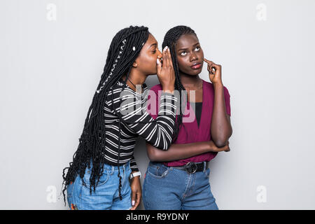 Porträt von zwei glückliche junge afrikanische Frauen teilen Geheimnisse isoliert Stockfoto
