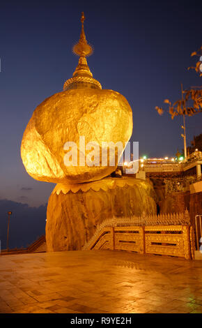 Die beleuchteten Goldenen Felsen von kyaikhtiyo Pagoda während der Dämmerung, birmanischen Volkes glauben, dass man von Buddhas Haare der Fels in der Balance halten, MYANMAR Stockfoto