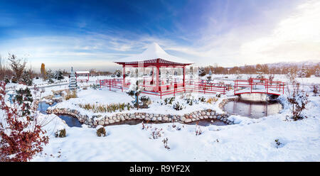 Winter Japanischer Garten mit roten Pagode in Bergen und blauem Himmel in dendra Park der erste Präsident in Almaty, Kasachstan Stockfoto