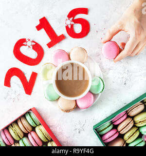 Bunte Französische macarons und Tasse Kaffee in der Nähe von 2016 Jahr Titel und Gegenwart Weihnachten Boxen auf weißem Hintergrund Stockfoto