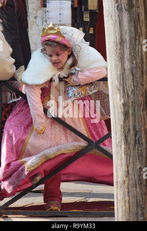 Calle Larga, Santa Croce, Venedig, Italien: kleines Mädchen in carnevale Fancy Dress lehnt sich an das Geländer in den Kanal von der Ponte del Megio zu suchen Stockfoto