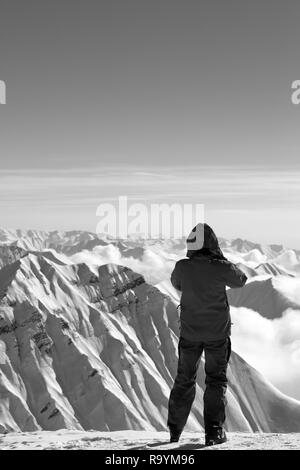 Skifahrer macht Foto auf der schneebedeckten Berge im sonnigen Wintertag. Kaukasus Berge im Winter, Georgien, Region Gudauri. Schwarz und Weiß getönten landscap Stockfoto