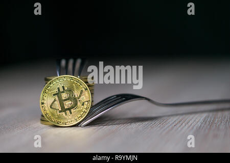 Bitcoin Neue harte Gabel ändern, physische Golden Crytocurrency Münze mit Gabel, Blockchain Konzept Stockfoto