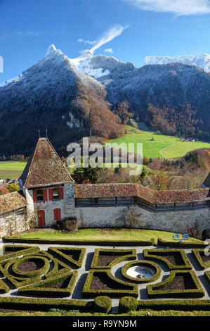 Französischer Garten und schneebedeckte Berge hinter dem Château de Gruyères, Fribourg, Schweiz Stockfoto