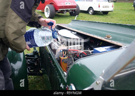 Dezember 2018 - Mann Füllen des Kühlers mit Wasser an der Redhill Oldtimer Treffen Stockfoto