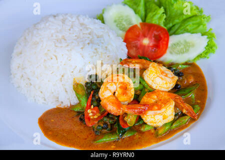 Gebratene Garnelen paste Rühren in Thai Red Curry mit Reis und Spiegelei würzig Gebratene Garnelen Curry gebratene Garnelen und gekochten Reis in Weiß Teller closeup Fried Stockfoto