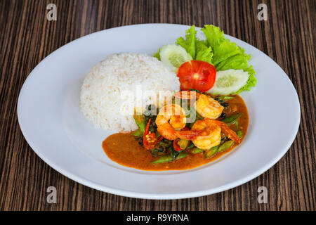 Gebratene Garnelen paste Rühren in Thai Red Curry mit Reis und Spiegelei würzig Gebratene Garnelen Curry gebratene Garnelen und gekochten Reis in Weiß Teller closeup Fried Stockfoto