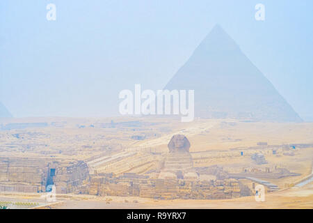 Die nebligen Morgen in Gizeh Nekropole mit einem Blick auf die Pyramide des Khafre und Großen Sphinx, der Wind trägt die Wolken der Wüste Sand, Kairo, Ägypten. Stockfoto