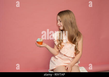 Kleines Mädchen essen Kuchen mit Sahne cupcake Süße Stockfoto