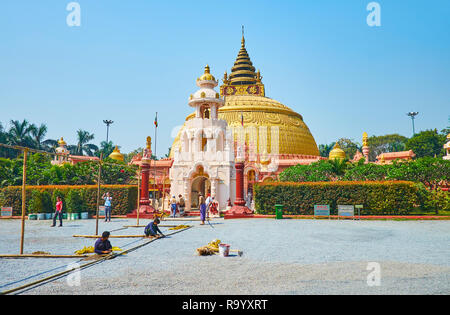 SAGAING, MYANMAR - 21. FEBRUAR 2018: Die Pagode von Sitagu International Buddhist Academy von Ziergarten mit getrimmt Büschen umgeben ist, Palm Stockfoto